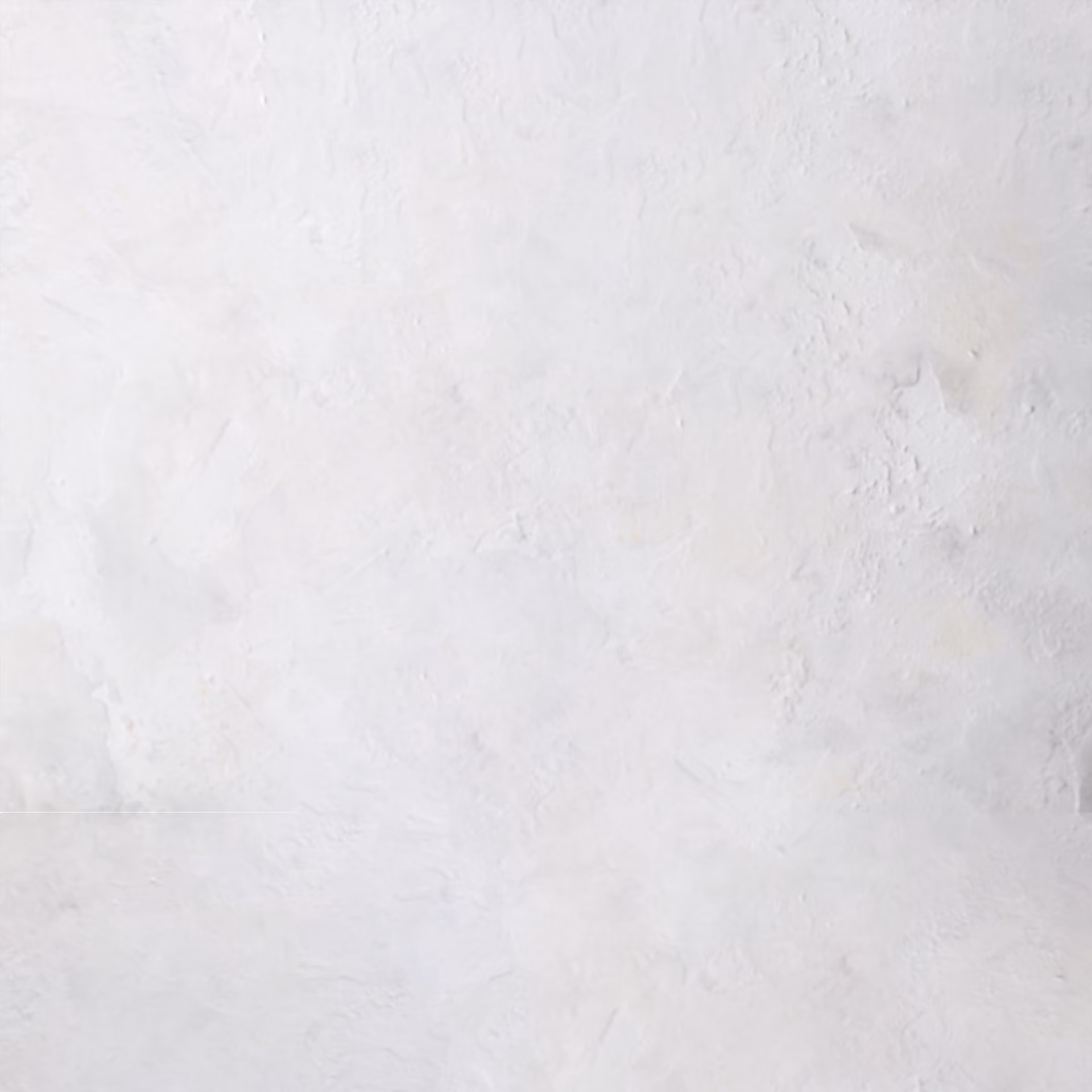 A textured white surface with subtle variations in shading, resembling plaster or painted concrete. The surface has a slightly rough appearance with soft, irregular patterns.